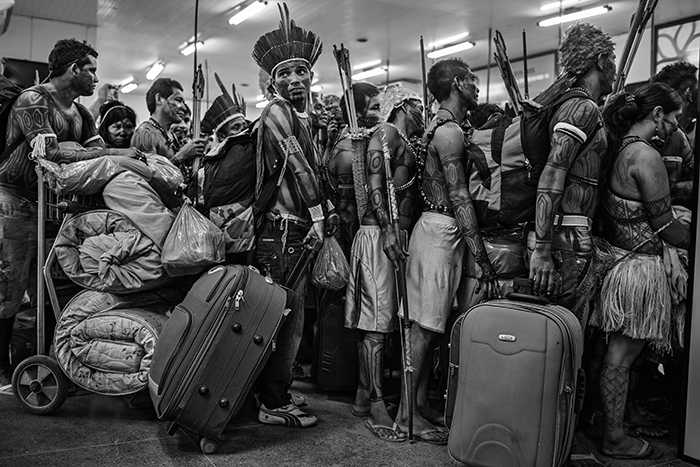 Mundurukus Indians line up to board a plane at Altamira Airport after protesting against the construction of the Belo Monte Dam on the Xingu River. The Mundurukus inhabit the banks of the Tapaj√≥s River, where the government has plans to build new hydroelectric projects. Even after counter pressure from indigenous people, environmentalists and non-governmental organizations, the Belo Monte project was built and completed in 2019.