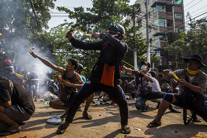 Protesters using slingshots and other homemade weapons in a clash with security forces in March. “You see these young men with slingshots and homemade weapons that could barely kill a bird, facing a military,” The Times’ photographer said. “They’re fighting for their freedom and democracy.”